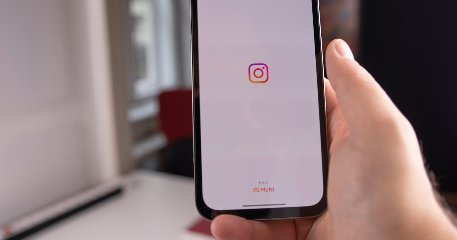 Elinde Instagram açık telefon tutan bir kişiyi gösteren Instagram algoritması kapak görseli